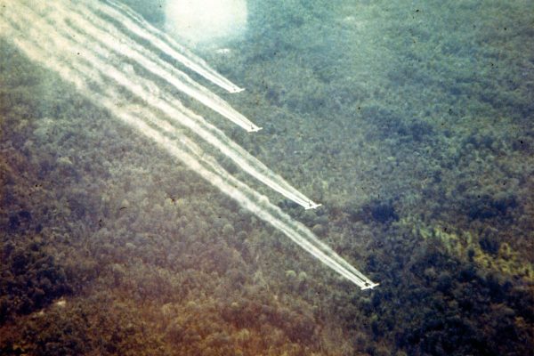 Us military planes flying over forest spraying agent orange.