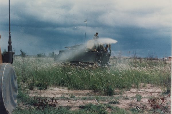 Us army armored personnel carrier spraying agent orange in field.